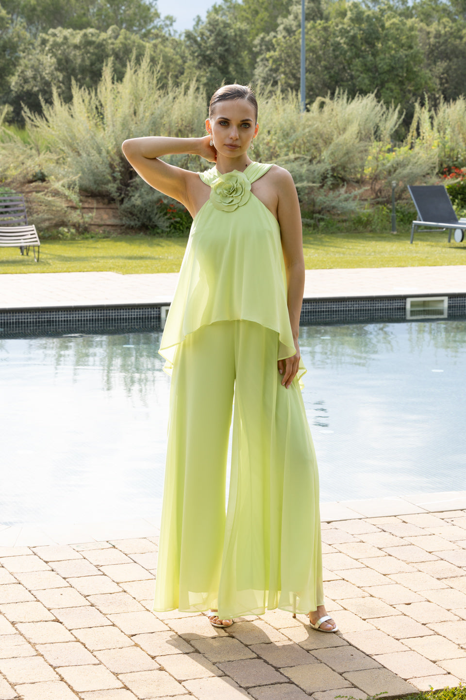 Luce sofisticada con este mono en verde pastel, ideal para bodas, comuniones y celebraciones. Su diseño de dos piezas con capa fluida y detalle floral en el cuello aporta frescura y elegancia para un look moderno y ligero.
